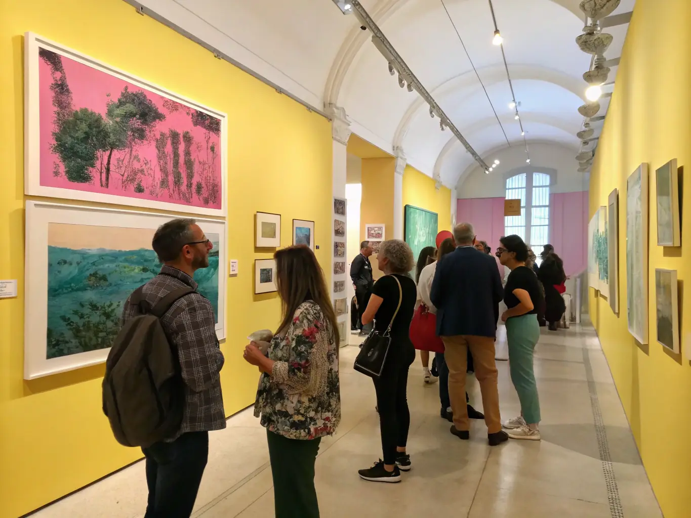 A dynamic image of the annual art exhibition, with numerous artworks displayed and visitors admiring the pieces. The scene captures the excitement and community engagement generated by the event.